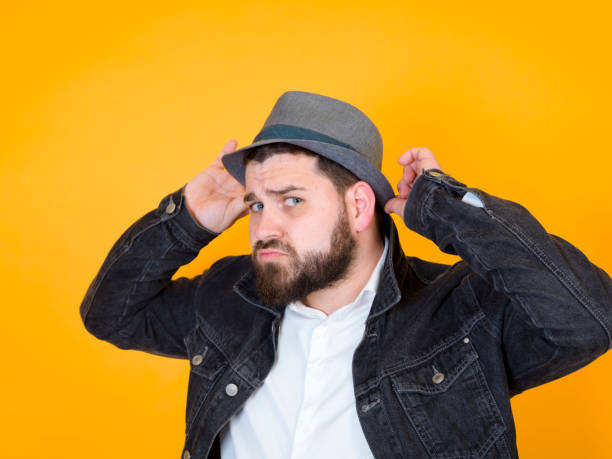 istock cool man with hat in front of yellow, orange background 1176980237