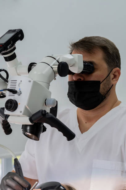 istock Doctor orthodontist examines a patient’s teeth under a modern microscope 1176980666