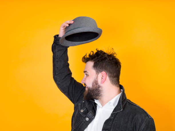 cool man with hat and black beard in front of yellow, orange background
