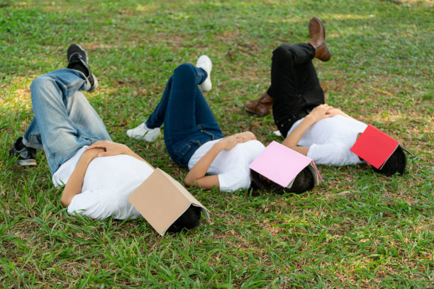 istock Funny students sleeping with books covering their face. Lazy and relaxation concept. 1176982173