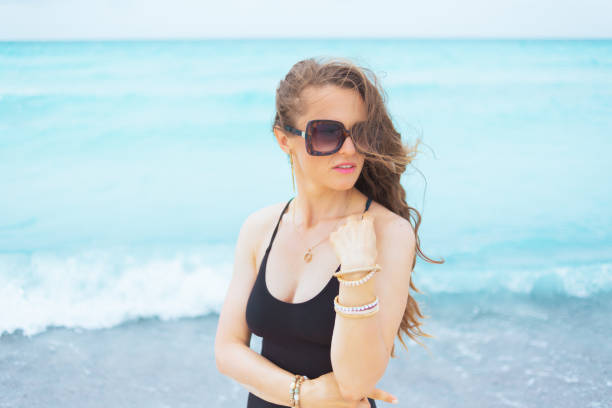 istock modern middle age woman on white beach looking aside 1176987082