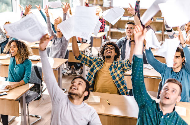 istock Large group of cheerful students having fun while celebrating the end of a class in the classroom. 1176987321