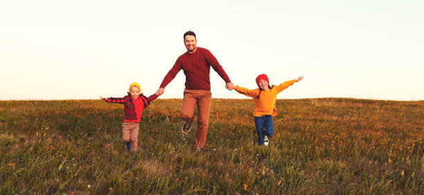 happy family father and children in autumn nature at sunset happy family father and children running in autumn nature at sunset 11904 stock pictures, royalty-free photos & images