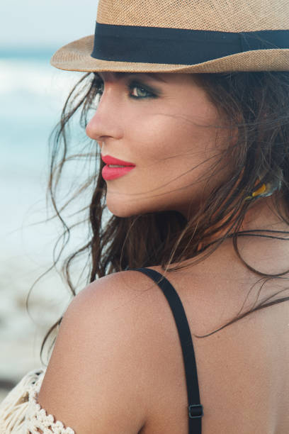 istock Beautiful woman wearing a hat on the beach 1176990458