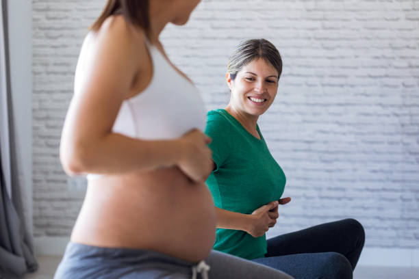 hermosa mujer embarazada con su fisioterapeuta haciendo ejercicios de pilates preparándose para el parto. - human pregnancy yoga exercising prenatal care fotografías e imágenes de stock