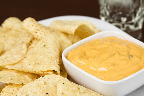 White Corn Tortilla Chips and Cheese Dip  cheese sauce stock pictures, royalty-free photos & images