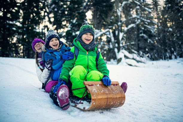 istock Children tobogganing in winter forest. 1176997492