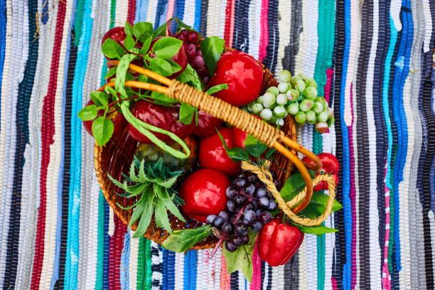 cesta de frutas. cesta con manzanas, uvas. cosecha fresca. exposición agrícola - basket wicker marinated preserves fotografías e imágenes de stock