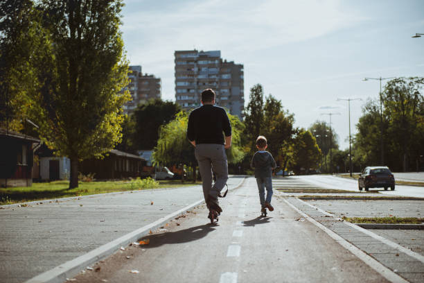istock Little boy riding a push scooter with his dad 1177001285