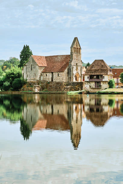 Looking across the Dordogne River towards the ancient Chapelle des Penitents in the village of Beaulieu sur Dordogne in France.
