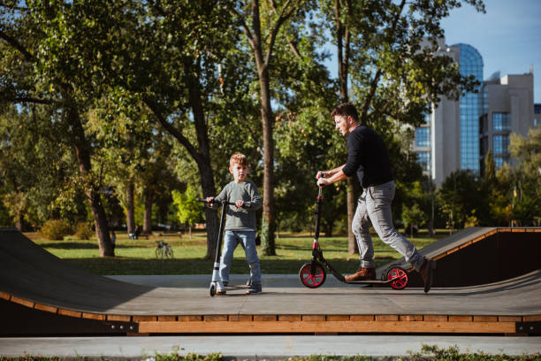 istock Little boy riding a push scooter with his dad 1177001342