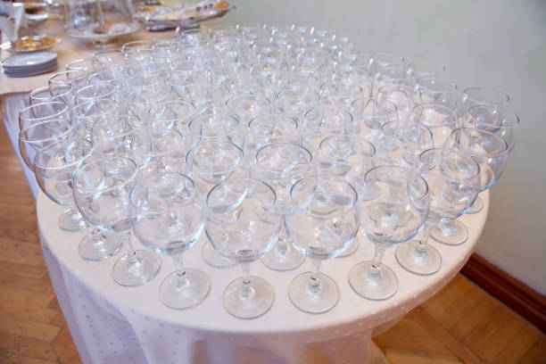 A lot of wine glasses in a row .Empty clean glasses standing in a row on a table prepared by the bartender for champagne and wine. Several of transparent glasses on a rack. Catering for the event.