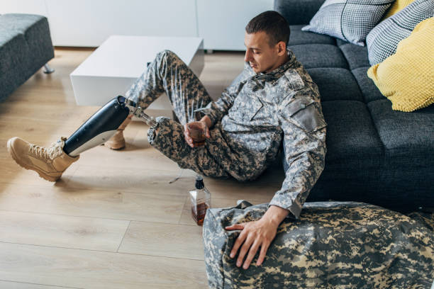istock Depressed soldier with amputee leg drinking alcohol 1177004742