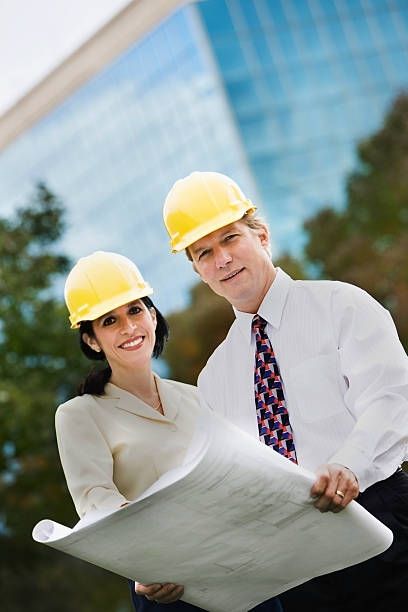istock Two People Wearing  Hardhats Outside 117700557