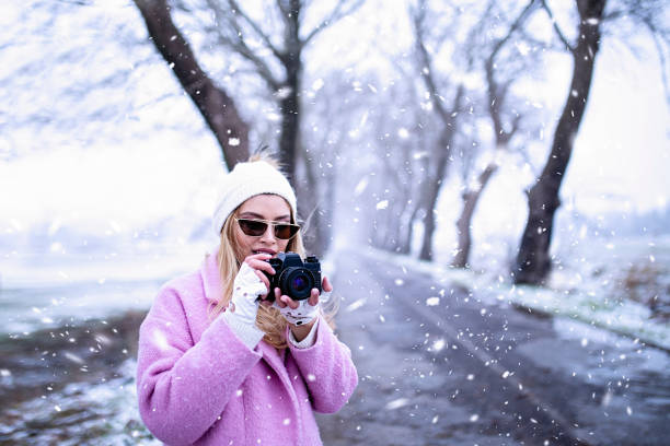 woman taking photos in snowy