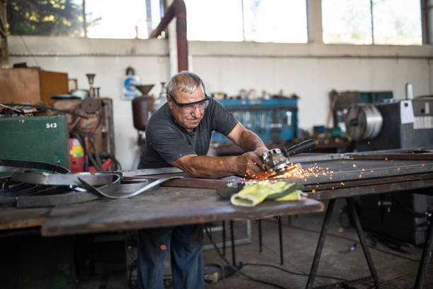 istock Manual worker grinding steel table in production hall 1177009146