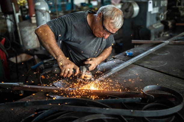 istock Manual worker grinding steel table in production hall 1177009213