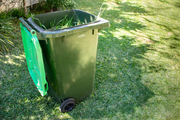 istock Green bin container filled with garden waste. Spring clean up in the garden. Recycling garbage for a better environment. 1177012419