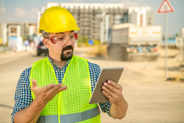 недовольный работник, инженер или архитектор с цифровым планшетом перед грузовиком - digital tablet construction truck manual worker стоковые фото и изображения