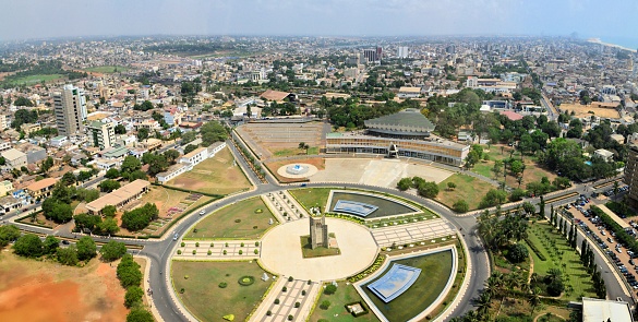 Lomé, Togo: cityscape of the Togolese capital - skyline seen from above the main square (Place de l'Independance) and the governement area, with the Atlantic Ocean on the top right
