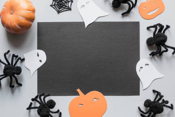 istock Halloween blank with space for text and party decor, black spiders, pumpkin, white ghost on grey. Flat lay, top view, copy space. 1177014144