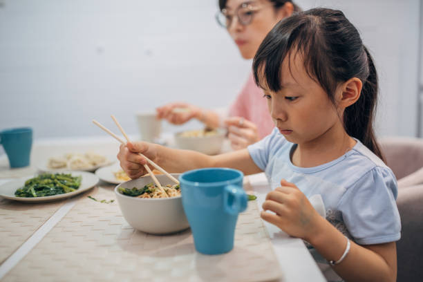 istock Mother and daughter eating together 1177014589