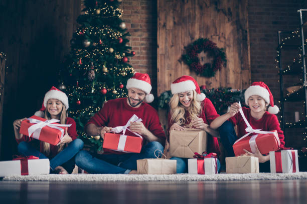 zdjęcie wielkiej rodziny zastanawiał się tata mama siostra brat otwarcie x-mas prezenty siedzi podłoga w pobliżu zdobione girlanda światła newyear drzewo wewnątrz nosić santa caps czerwony sweter - winter family child snow zdjęcia i obrazy z banku zdjęć