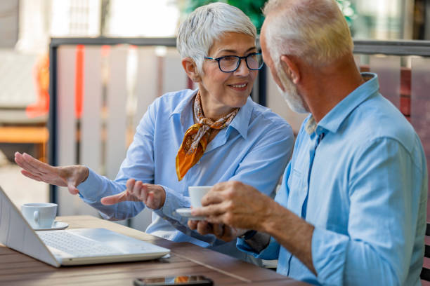 istock Two Older People in the City Restaurant Working with Laptop 1177016275