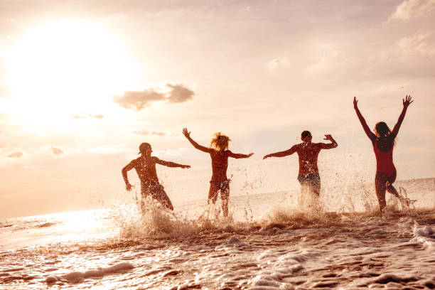 istock Happy friends having fun at sunset sea beach 1177016334