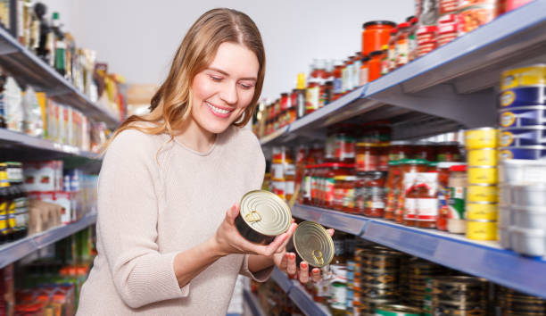istock Nice female in the shop holding preserved  fish 1177016759