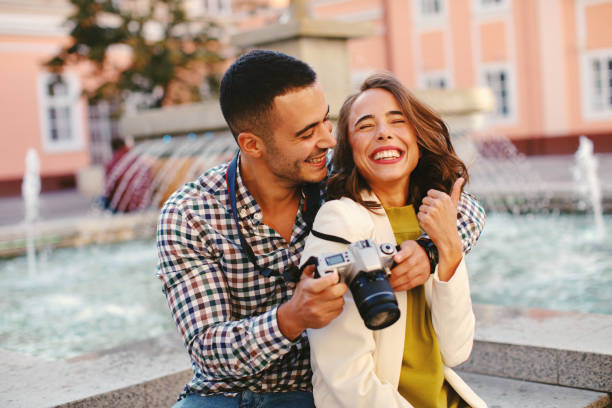 街で写真を作る幸せな若いカップルの観光客 ストックフォト