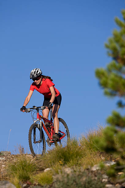 belle jeune femme faire du vélo tout-terrain - mountain biking colorado action cycling photos et images de collection