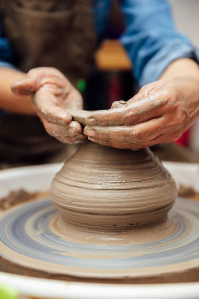 istock Senior female potter working on pottery wheel while sitting  in her workshop 1177025337