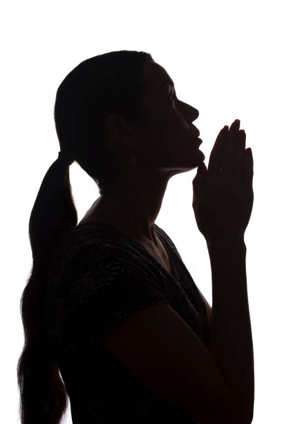 istock Young woman looking up with hope and request - silhouette 1177027958