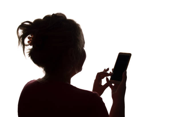 istock Silhouette girl from the back with mobile smart phone - isolated 1177028298