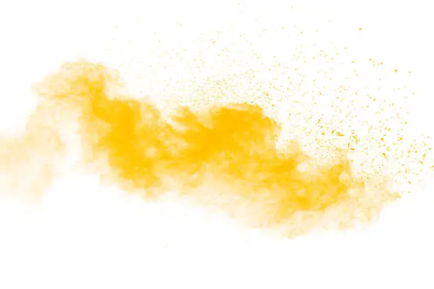 Photo of Abstract yellow powder explosion on white background. Freeze motion of yellow  dust particles splash.