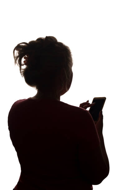 istock Silhouette girl from the back with mobile smart phone - isolated 1177029313
