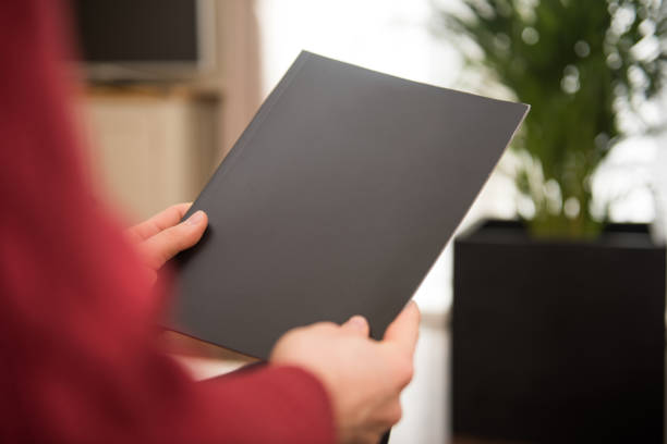 istock Woman holding black blank brochure with copy space 1177031226