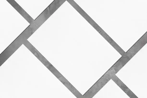 Photo of Closeup of empty white rectangle poster mockups lying diagonally on grey concrete background