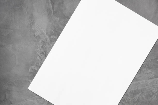 istock Close up of empty white rectangle poster mockup lying diagonally on grey concrete background 1177031913