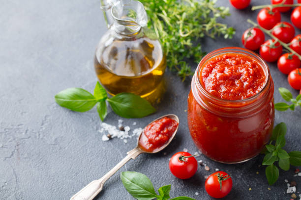 traditional tomato sauce in a glass jar with fresh herbs, tomatoes and olive oil. copy space. - restaurant pasta italian culture dinner imagens e fotografias de stock