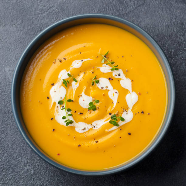 Pumpkin, carrot cream soup in a bowl. Slate background. Close up. Top view Pumpkin, carrot cream soup in a bowl. Slate background. Close up. Top view squash soup stock pictures, royalty-free photos & images