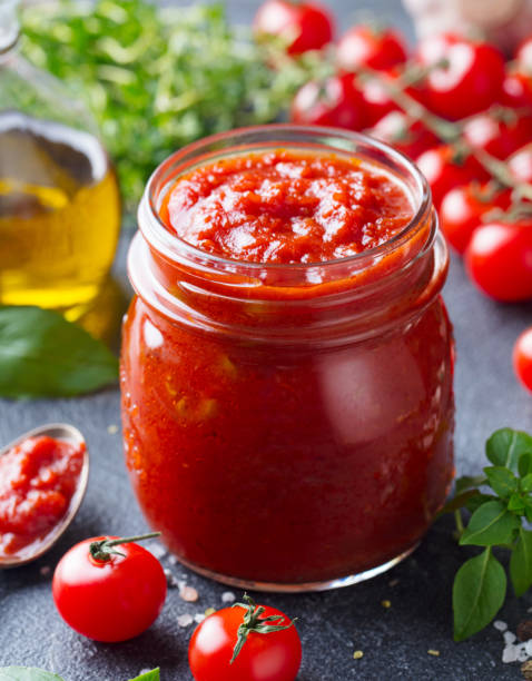 tradycyjny sos pomidorowy w szklanym słoiku ze świeżymi ziołami, pomidorami i oliwą z oliwek. z bliska. - tomato sauce jar zdjęcia i obrazy z banku zdjęć