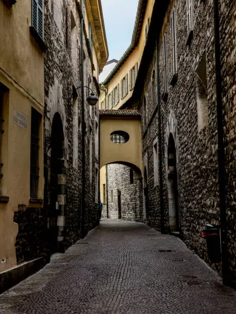 A laneway through a small town near lake Como with stone architectural features.