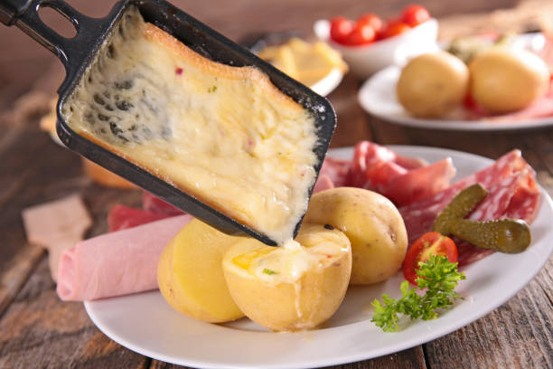 раклетт сыр плавления с картофелем, салями и ветчиной - raclette cheese стоковые фото и изображения