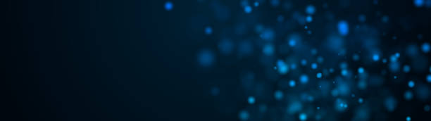 Computer generated many of blue spots big and small with bokeh on a black background. Widescreen 3d rendering