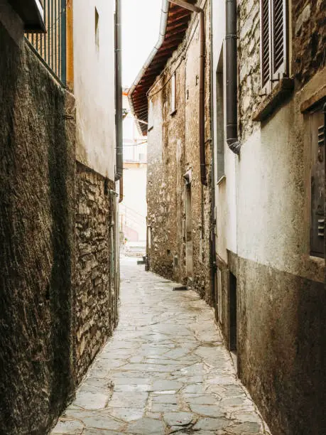 A laneway through a small town near lake Como with stone architectural features.