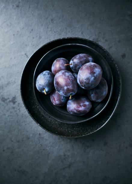istock Fresh plums in dark bowl. Still life. Black background 1177048309