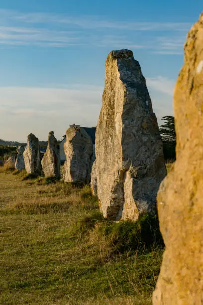 view of prehistoric monolith stone alignments in Brittany in warm morning light with the sun shining brightly