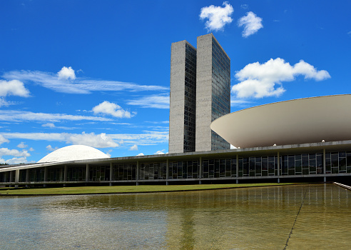 Brasília, Federal District, Brazil, January 29th, 2014: the Congress building seen from the pond - in this bicameral parliament the dome houses the upper chamber (Senate) and the saucer the lower house (the Chamber of Deputies) - Monumental Axis